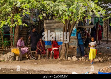 Arusha, Tansania, Afrika. 3. Februar 2022. Leben in einem afrikanischen Dorf. Afrikanische Reise . Maasai-Männer in traditioneller Kleidung sitzen auf Stühlen in der Nähe des Hauses Stockfoto