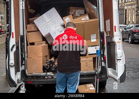 DPD-Fahrer schaut in den hinteren Teil seines Lieferwagens in Edinburgh. Stockfoto