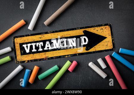 Vitamin D. Richtungspfeil mit Text auf dunklem Tafel. Stockfoto