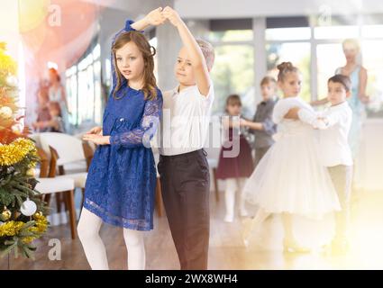 Tween Junge und Mädchen spielen Walzer während der Weihnachtsfeier in der Schule Stockfoto