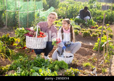 Eine Farmerin und ihre Tochter im Teenageralter halten einen Weidenkorb in der Hand Stockfoto