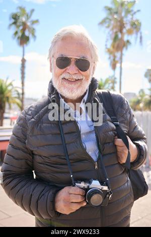 Vertikal. Porträt eines kaukasischen Seniorenmannes mit Bart und weißem Haar glücklich und lächelnd Stockfoto