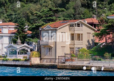 Blick von der Bosporus Meerenge auf die grünen Berge der asiatischen Seite, mit traditionellen Häusern und dichten Bäumen an einem Sommertag, Istanbul, Türkei Stockfoto