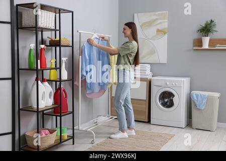 Eine junge Frau, die Hemd aus der Wäscherei nimmt Stockfoto