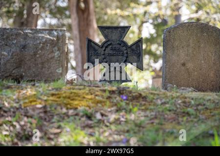 Metall Southern Cross of Honor Marker zwischen Grabsteinen im konföderierten Abschnitt des Stone Mountain Cemetery in der Nähe von Atlanta, Georgia. (USA) Stockfoto