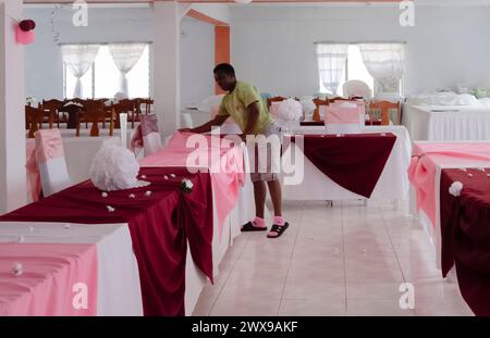 Eine Frau, die Einen Speisesaal für einen Hochzeitsempfang in Yardley Chase, St. Elizabeth in Jamaika vorbereitet Stockfoto