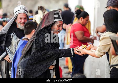 Antigua, Guatemala. März 2024. Kostümierte Figuren, die die Juden in Semana Santa Prozessionen repräsentieren, stellen sich für eine Mahlzeit während der Feierlichkeiten am Heiligen Donnerstag, 28. März 2024 in Antigua, Guatemala, an. Die opulenten Prozessionen, detailgetreuen Alfombras und jahrhundertealten Traditionen ziehen mehr als 1 Million Menschen in die alte Hauptstadt. Quelle: Richard Ellis/Richard Ellis/Alamy Live News Stockfoto