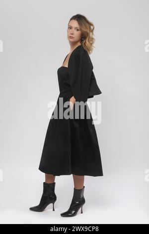 Serie von Studiofotos von weiblichem Model mit schwarzem Blazer und schwarzem Midikleid Stockfoto