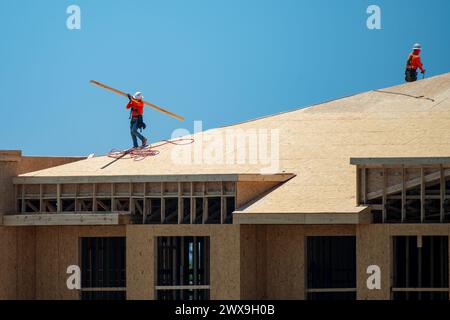 Dachüberdachung auf dem Dach. Dachbauer installieren neues Dach. Bauarbeiter, die eine große Dachwohnung überdacht haben. Zimmermann Stockfoto
