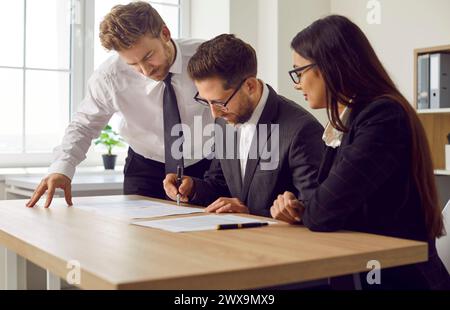 Die Mitarbeiter treffen sich im Amt, machen einen Deal und unterschreiben die Vereinbarung über einen Geschäftsvertrag Stockfoto