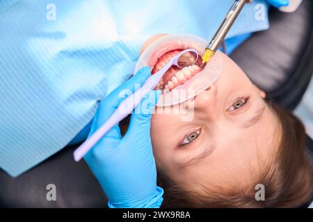 Der Zahnarzt injiziert Narkose in das Zahnfleisch eines Teenager-Mädchens Stockfoto