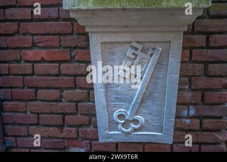 Eine innovative, schlüsselförmige Skulptur ziert eine Amsterdamer Straßenmauer und verbindet künstlerischen Ausdruck mit zeitgenössischem Design im Stadtbild. Stockfoto