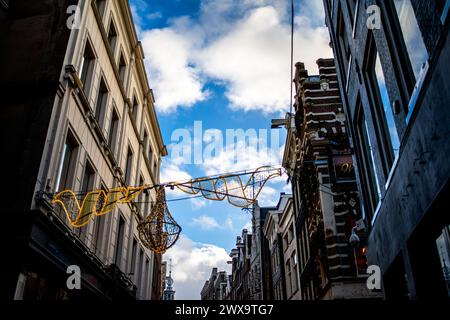 Erkunden Sie den Charme und das architektonische Erbe Amsterdams durch seine lebhaften Straßen, wo ikonische Gebäude ein malerisches Stadtbild prägen. Stockfoto