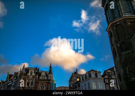 Erkunden Sie den Charme und das architektonische Erbe Amsterdams durch seine lebhaften Straßen, wo ikonische Gebäude ein malerisches Stadtbild prägen. Stockfoto