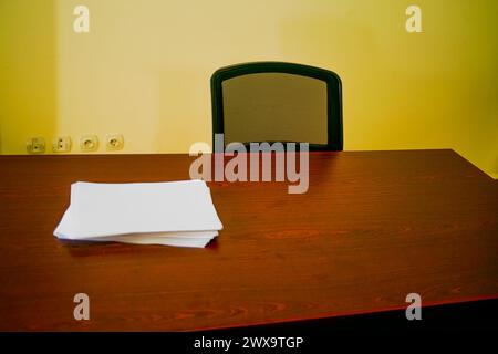 Ein makelloser Schreibtisch mit ordentlich gestapelten weißen A4-Papieren schafft einen organisierten und effizienten Arbeitsplatz für professionelle Zwecke. Stockfoto