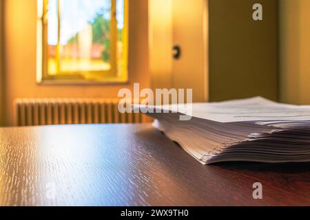 Ein makelloser Schreibtisch mit ordentlich gestapelten weißen A4-Papieren schafft einen organisierten und effizienten Arbeitsplatz für professionelle Zwecke. Stockfoto