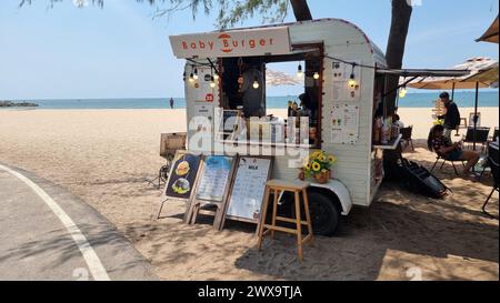 Rayong Thailand 13. März 2024, Ein lebhafter Food Truck parkt am Sandstrand eines Strandes, der Strandbesuchern unter klarem blauen Himmel köstliche Gerichte serviert. Stockfoto