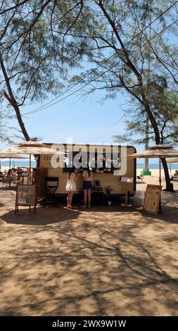 Rayong Thailand 13. März 2024, Ein lebhafter Food Truck parkt an einem Sandstrand, der Strandgängern an einem sonnigen Tag köstliche Mahlzeiten bietet. Stockfoto