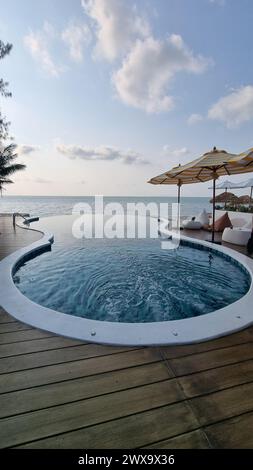 Bangsaray Pattaya Thailand 28 Februar 2024, Ein atemberaubender, großer Swimmingpool fügt sich nahtlos mit einer Holzterrasse unter freiem Himmel. Stockfoto