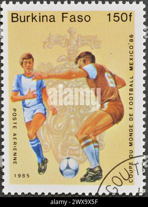 Von Burkina Faso gedruckte Briefmarke, auf der Fußballspieler, FIFA Fussball-Weltmeisterschaft 1986 - Mexiko, um 1985 gezeigt werden. Stockfoto