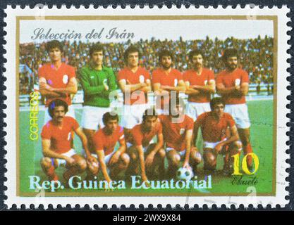 Von Äquatorialguinea gedruckte Briefmarke, die die iranische Fußballmannschaft zeigt, um 1977. Stockfoto