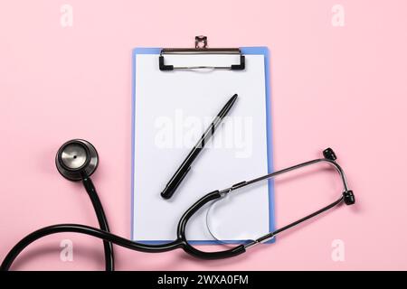 Endokrinologie. Stethoskop, Zwischenablage und Stift auf rosa Hintergrund, Draufsicht Stockfoto