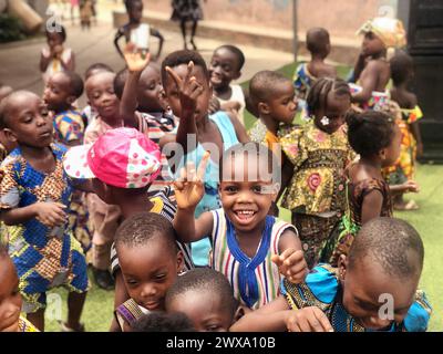 Eine Gruppe von Kindern, die in Akim Osenase, Ghana, glücklich mit den Händen winken Stockfoto