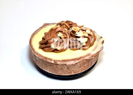 Ein Korb mit Kuchen mit Sahne und Hüttenkäse liegt auf weißem Hintergrund. Stockfoto