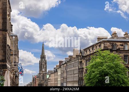 Edinburghs High Street erwacht in dieser malerischen Szene zum Leben, wo der schottische Saltyre über Steinfassaden flattert und ein Turm anmutig aufsteigt Stockfoto