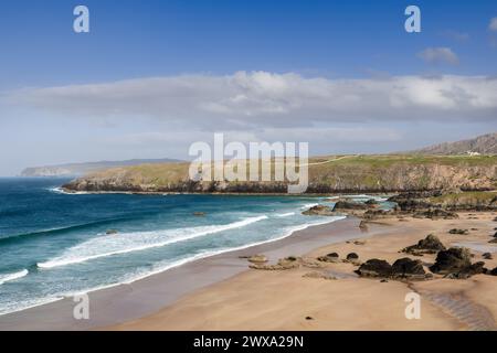 Ein klarer Tag am Durness Beach, Schottland, zeigt eine unberührte Küste mit türkisfarbenen Wellen, die über Sandstrände, gespickt mit Felsen, gegen den Rücken gleiten Stockfoto