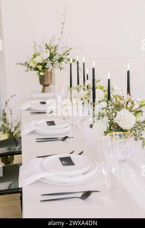 Schicker Hochzeitstisch mit floraler Eleganz und Kerzenlicht Stockfoto