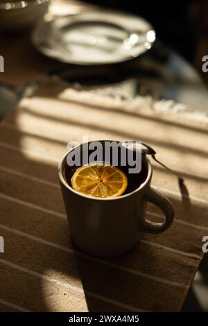 Schwarzer Tee mit Zitrone auf dem Tisch, kalt mit heißem Getränk. Stockfoto