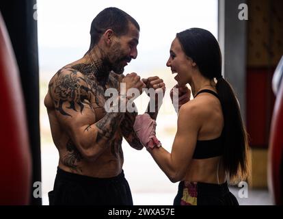 Fröhliches Paar, das Muai Thai im Fitnessstudio übt Stockfoto