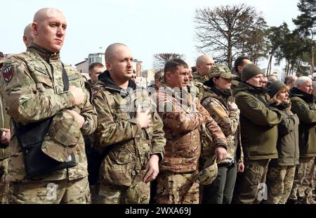 IRPIN, UKRAINE - 28. MÄRZ 2024 - während der Ereignisse, die auf dem zentralen Platz anlässlich des zweiten Jahrestages der Befreiung der Stadt von den russischen Invasoren in Irpin, Region Kiew, Nordukraine, stattfinden, stehen Soldaten zur Aufmerksamkeit. Stockfoto