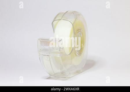 Ein Kunststoffkoffer mit einer Rolle Klebeband auf weißem Hintergrund Stockfoto