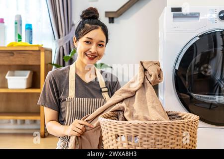 Eine südostasiatische Frau wäscht Kleidung in einem Waschraum Stockfoto