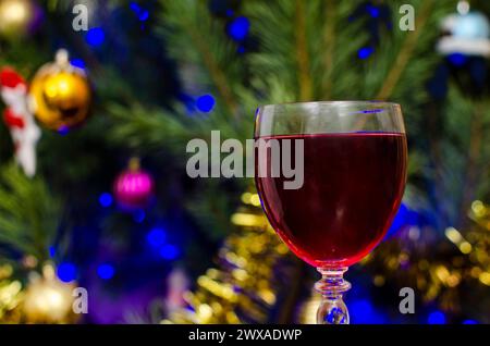 Rotweinglas mit Teilabschnitt und Weihnachtsbeleuchtung im Hintergrund Stockfoto