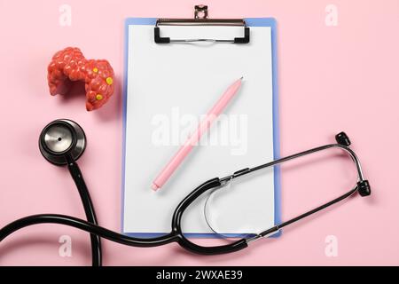 Endokrinologie. Stethoskop, Clipboard, Modell der Schilddrüse und Stift auf rosa Hintergrund, flache Lage Stockfoto