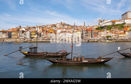 Alte Boote säumen den Fluss Douro, mit dem bezaubernden Viertel Ribeira im Hintergrund, Porto, Portugal. Stockfoto