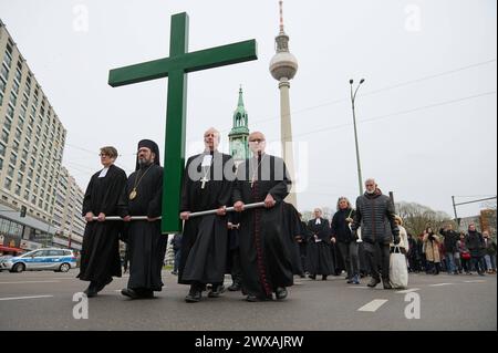 Die großen christlichen Kirchen begehen am 29.03.2024 wieder eine Karfreitagsprozession durch Berlins Mitte. Sie sollen an den Leidensweg Christi erinnern. An der Spitze des Zuges wird traditionell ein rund 50 Kilogramm schweres Kreuz getragen. Die oekumenische Prozession beginnt im Anschluss an einen Gottesdienst in der Marienkirche im Bild am Alexanderplatz. Von dort fuehrt sie zum Berliner Dom, ueber die Straße unter den Linden zur Neuen Wache und endet auf dem Bebelplatz vor der Hedwigs-Kathedrale. Im Bild vlnr.: Superintendentin Silke Radosh-hinder, Bischof Emmanuel von Christoupolis, Erz Stockfoto