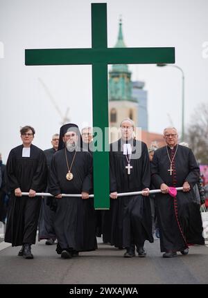 Die großen christlichen Kirchen begehen am 29.03.2024 wieder eine Karfreitagsprozession durch Berlins Mitte. Sie sollen an den Leidensweg Christi erinnern. An der Spitze des Zuges wird traditionell ein rund 50 Kilogramm schweres Kreuz getragen. Die oekumenische Prozession beginnt im Anschluss an einen Gottesdienst in der Marienkirche im Bild am Alexanderplatz. Von dort fuehrt sie zum Berliner Dom, ueber die Straße unter den Linden zur Neuen Wache und endet auf dem Bebelplatz vor der Hedwigs-Kathedrale. Im Bild vlnr.: Superintendentin Silke Radosh-hinder, Bischof Emmanuel von Christoupolis, Erz Stockfoto