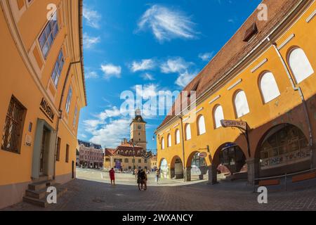 BRASOV, RUMÄNIEN, 11. JULI 2020: Straße mit Häusern aus dem 18. Bis 19. Jahrhundert und Blick auf das 1420 erbaute Gemeindehaus in der Mitte des Konzils Stockfoto