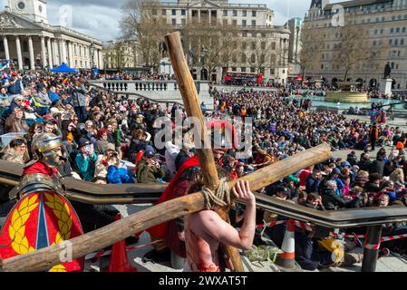 Trafalgar Square, London, Großbritannien. März 2024. Am Karfreitag am Osterabend präsentierte die Theaterbesetzung von Wintershall „die Passion Jesu“, ein Stück, das die Bibelgeschichte Christi durch die „Wunder“, das letzte Abendmahl, und die Kreuzigung durch die Römer, bevor sie wieder zur Auferstehung aufstehen, alle benutzten den Trafalgar Square als Bühne für dieses kostenlose öffentliche Ereignis. Eine große Menschenmenge von Tausenden, die auf den Platz gepackt sind, beobachtete, wie Christus vom Schauspieler Peter Bergin dargestellt wird Stockfoto
