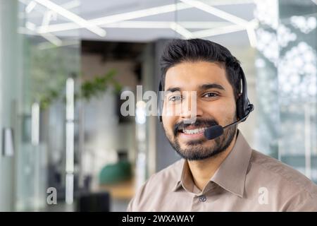 Professioneller männlicher Kundendienstmitarbeiter, der ein Headset in einer modernen Büroumgebung trägt und Hilfe leistet. Stockfoto