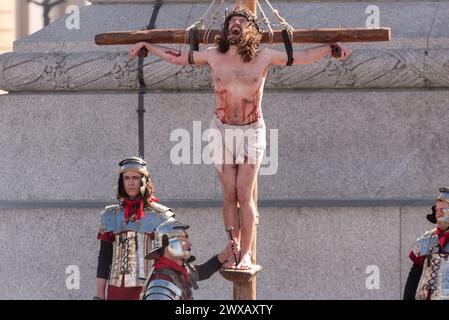 Trafalgar Square, London, Großbritannien. März 2024. Am Karfreitag am Osterabend präsentierte die Theaterbesetzung von Wintershall „die Passion Jesu“, ein Stück, das die Bibelgeschichte Christi durch die „Wunder“, das letzte Abendmahl, und die Kreuzigung durch die Römer, bevor sie wieder zur Auferstehung aufstehen, alle benutzten den Trafalgar Square als Bühne für dieses kostenlose öffentliche Ereignis. Eine große Menschenmenge von vielen Tausenden, die auf den Platz gepackt sind, beobachtete, wie Christus vom Schauspieler Peter Bergin am Kreuz dargestellt wird Stockfoto