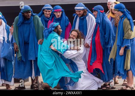 Trafalgar Square, London, Großbritannien. März 2024. Am Karfreitag am Osterabend präsentierte die Theaterbesetzung von Wintershall „die Passion Jesu“, ein Stück, das die Bibelgeschichte Christi durch die „Wunder“, das letzte Abendmahl, und die Kreuzigung durch die Römer, bevor sie wieder zur Auferstehung aufstehen, alle benutzten den Trafalgar Square als Bühne für dieses kostenlose öffentliche Ereignis. Eine große Menschenmenge von Tausenden, die auf den Platz gepackt sind, beobachtete, wie Christus vom Schauspieler Peter Bergin mit Jüngern dargestellt wird Stockfoto