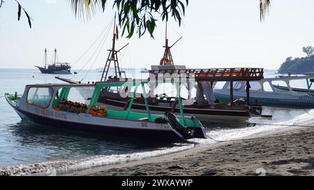 Einige Boote, die den Einwohnern der Lombok gehören, lehnen sich am Strand an. Dieses Boot wird benutzt, um zu den Gili Inseln zu überqueren Stockfoto