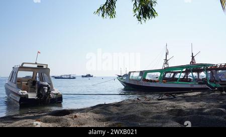 Einige Boote, die den Einwohnern der Lombok gehören, lehnen sich am Strand an. Dieses Boot wird benutzt, um zu den Gili Inseln zu überqueren Stockfoto