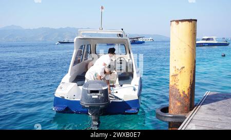 Die Männer sind damit beschäftigt, den Speedboot-Motor vorzubereiten Stockfoto