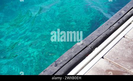 Der Hintergrund besteht aus natürlichem türkisfarbenem Meerwasser und Holzlinien Stockfoto